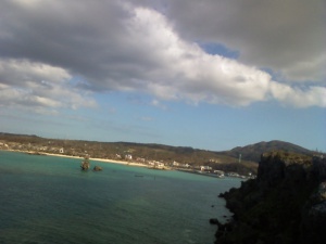 手前に海　奥にリゾート地　雲のコントラストがいい