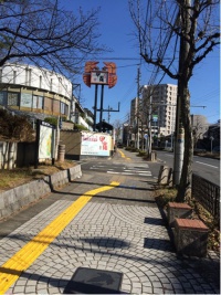 かに料理屋　看板の上に蟹の絵が　歩道には点ブロが敷かれている。